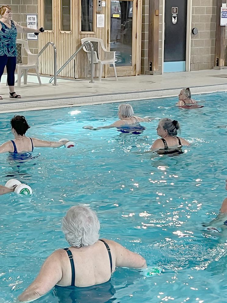 Members doing water exercise with styrofoam weights